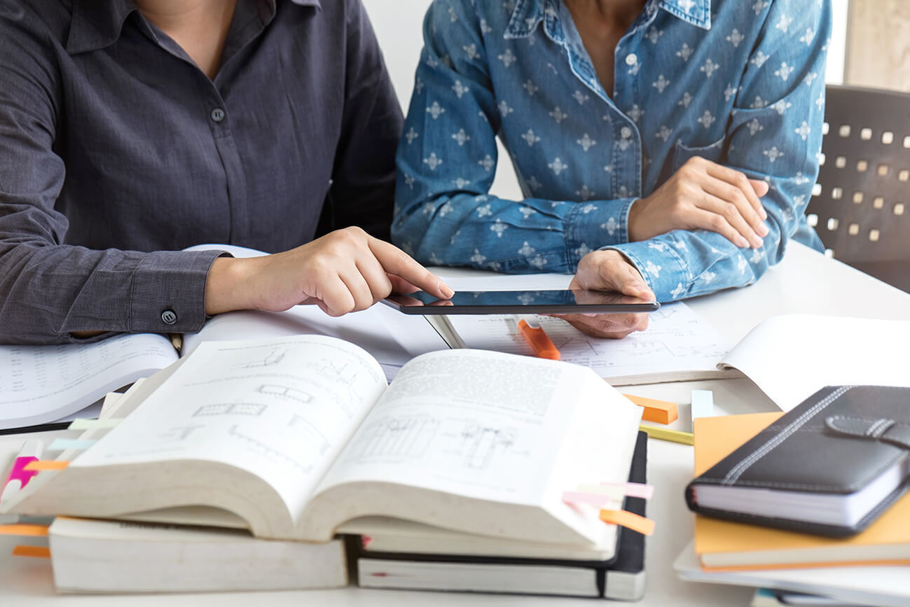 Une professeure et son élève travaillent les mathématiques avec des manuels de classe